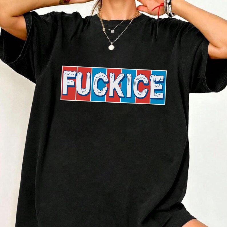 May include: Black t-shirt with the word "FUCKICE" in white, set against a red and blue rectangular design. The text has a wavy, ice-like appearance. The shirt is a casual, oversized style.