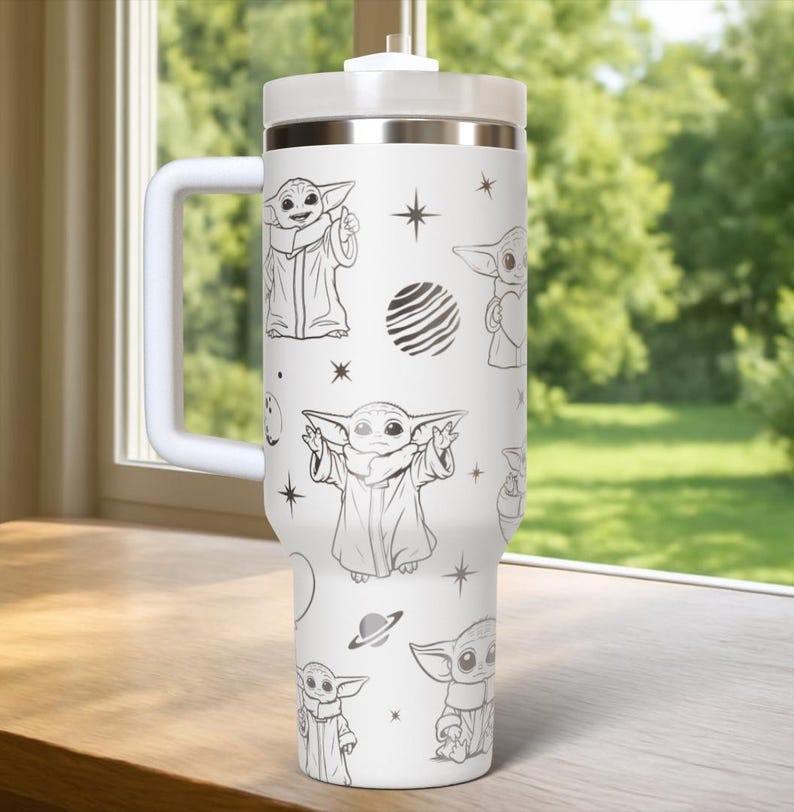 Puede incluir: Vaso t&eacute;rmico blanco con asa, con un patr&oacute;n repetido de un personaje de dibujos animados, estrellas y planetas. El vaso tiene una tapa blanca y una banda plateada cerca de la parte superior.