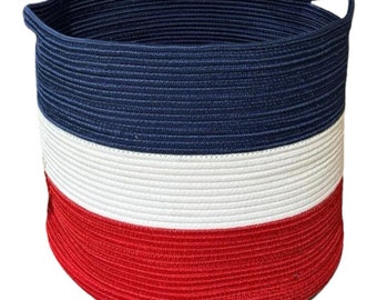 May include: A large, blue, white, and red striped rope storage basket with a single handle.