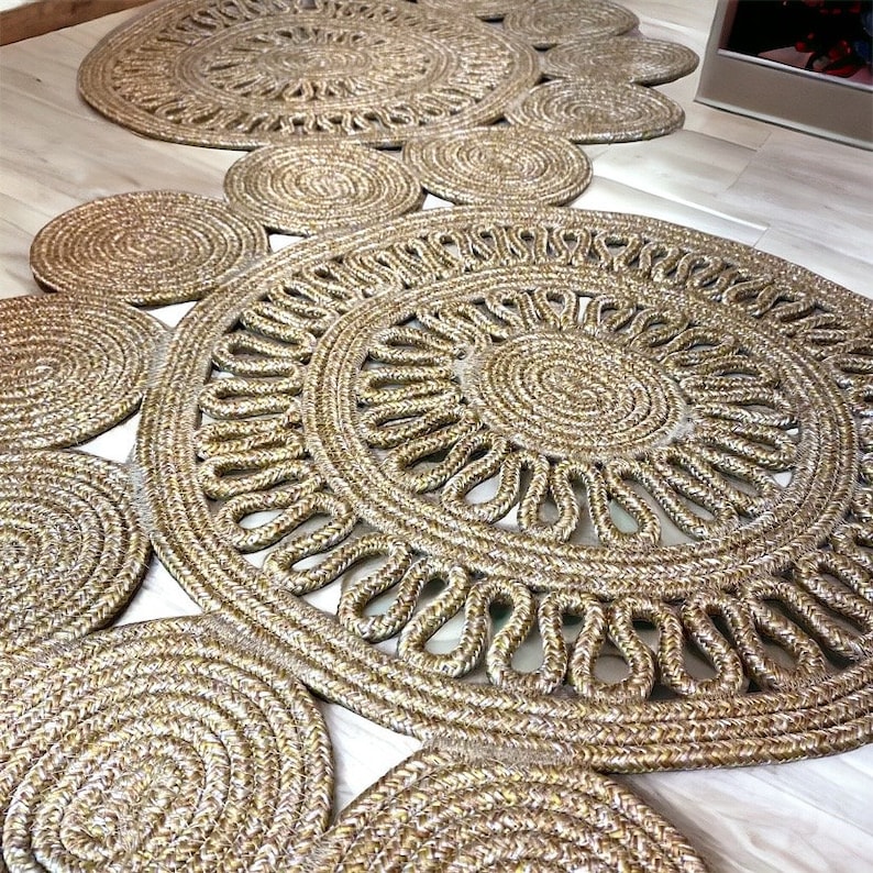 Puede incluir: Una alfombra trenzada de color dorado y marr&oacute;n con un dise&ntilde;o circular. La alfombra est&aacute; hecha de fibras naturales y tiene una superficie texturizada.