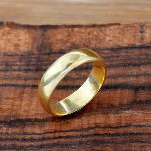 May include: A simple gold wedding band with a smooth, polished finish.