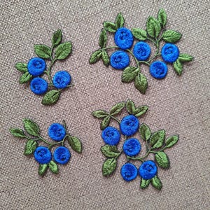 Può includere: Quattro toppe ricamate con mirtilli blu su steli e foglie verdi. Le toppe sono perfette per aggiungere un tocco di natura a vestiti, borse o altri oggetti artigianali.