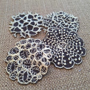 Peut inclure: Quatre appliques en tissu brodé noir et blanc en forme circulaire. Les appliques ont un design délicat de dentelle.