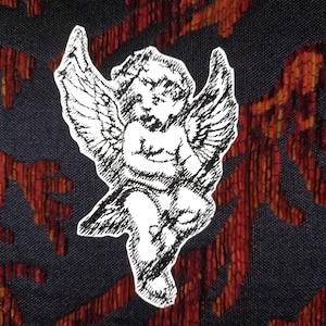 Könnte beinhalten: Schwarzweiß-Illustration eines Cherubins mit Flügeln vor einem roten und orangefarbenen gemusterten Hintergrund.