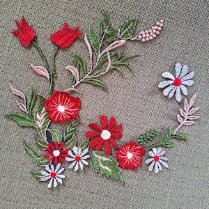 May include: Embroidered floral patch with red, white, and green flowers and leaves. The patch features daisies and tulips, with pink accents. The design is set against a textured, olive-green background.