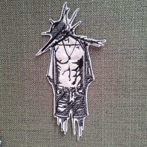 May include: Black and white embroidered patch of a person with a spiky crown, wearing a jacket and jeans.