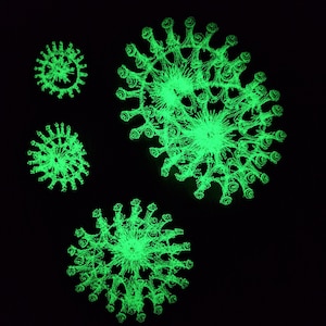 Peut inclure: Quatre motifs circulaires lumineux verts et complexes sur un fond noir. Les motifs sont de forme similaire, mais de tailles différentes.