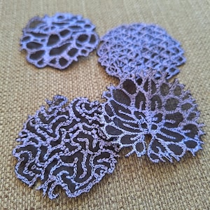 Peut inclure: Quatre doilies en dentelle crochetée de couleur violette et noire avec des motifs complexes.
