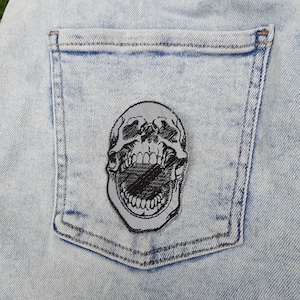 Broderad lapp med strykjärn på skallen och reflekterande