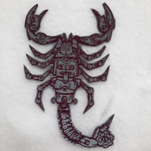 Könnte beinhalten: Ein gestickter Skorpion-Patch in Burgunderrot mit einem detaillierten Design. Der Skorpion ist mit einem segmentierten Körper, Zangen und einem Stachel dargestellt.