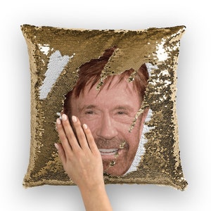 May include: Gold sequin pillow with a reversible image of a man's face. The image is partially revealed by a hand pushing the sequins aside.