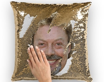 May include: A gold sequin pillow with a hidden image of a man's face. The sequins are reversible, so you can change the image by rubbing your hand across the pillow.