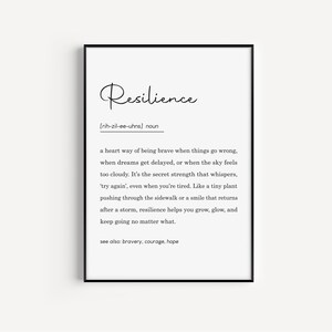 May include: A framed print with the word "Resilience" in elegant script. Below, a definition explains resilience as a way of being brave. The black frame surrounds a white background with black text, suitable for home or office decor.