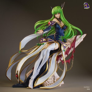 May include: A detailed anime-style figurine of a character with long green hair, wearing a dark blue and white gown with gold trim and red accents. The figure is posed sitting on a textured, light-colored rock formation with a gold chain detail.