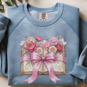 May include: A white ceramic mug with a black handle and the text "But First, Coffee" in a bold, black font. The mug is set against a neutral background, highlighting its simple design.