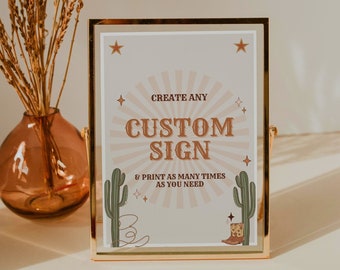 May include: A gold-framed sign with a beige background and a sunburst design. The sign says "Create any Custom Sign & Print as many times as you need". There are cactus and cowboy boot illustrations on the sign.