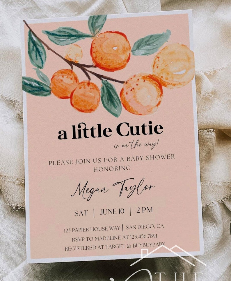 May include: A peach-colored baby shower invitation with a watercolor illustration of a branch with green leaves and orange fruit. The text reads "a little cutie is on the way!" and includes the name "Megan Taylor", the date "June 10", the time "2 PM", the address "123 Papier House Way, San Diego, CA", the RSVP information "RSVP to Madeline at 123.456.7891", and the registry information "Registered at Target & BuyBuyBaby".