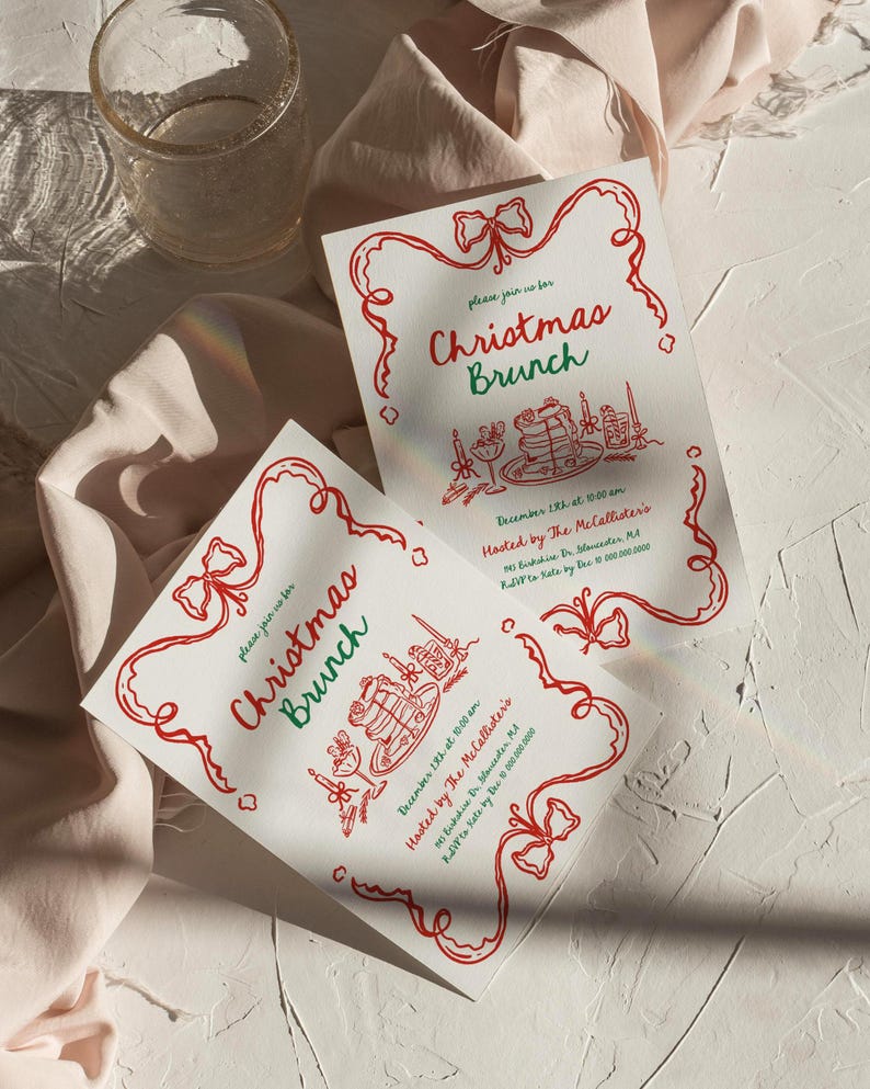 May include: Two white Christmas Brunch invitations with red and green text and illustrations. The invitations have a red ribbon border and include the date, time, and host information. A glass and fabric are in the background.