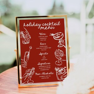 May include: A gold-framed sign with a red background lists a holiday cocktail menu. The menu includes options for wine, beer, spirits, signature cocktails, and non-alcoholic drinks. Each drink is illustrated with a hand-drawn image.