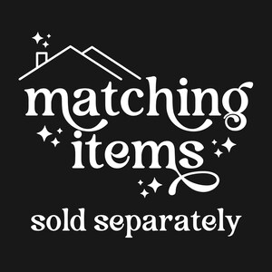 Może przedstawiać: Biały tekst na czarnym tle z napisem "matching items: sold separately" ze stylizowanym domem i gwiazdami nad tekstem.
