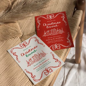 May include: Two Christmas Brunch invitations. One is red with white text and illustrations, the other is white with red text and illustrations. Both feature bow and ribbon designs. The invitations are on a woven chair.