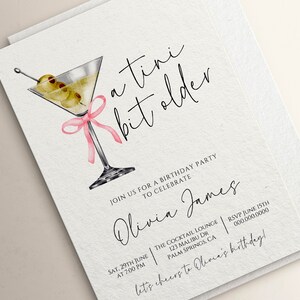 May include: A white invitation card with a martini glass illustration and pink ribbon. The text reads "a tini bit older" and "Join us for a birthday party to celebrate Olivia James". The invitation details include the date, time, location, and RSVP information.