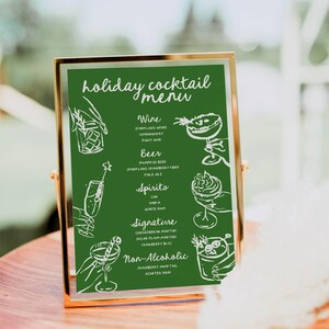 May include: A green chalkboard sign with a gold frame lists a holiday cocktail menu. The menu includes wine, beer, spirits, signature cocktails, and non-alcoholic options. Each drink is illustrated with a hand-drawn sketch.