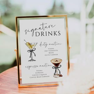May include: A printable sign with a gold frame listing two signature drinks: a dirty martini and an espresso martini. Each drink is illustrated with a watercolor drawing of a martini glass.