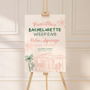 May include: A pink and green illustrated sign announcing a bachelorette weekend in Palm Springs, California. The sign features a stylized illustration of a house and palm trees.