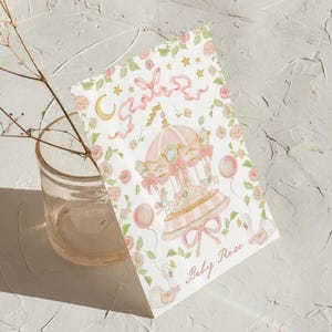 May include: A pink and white carousel with a gold star and ribbon design. The text "Baby Rose" is written below the carousel.