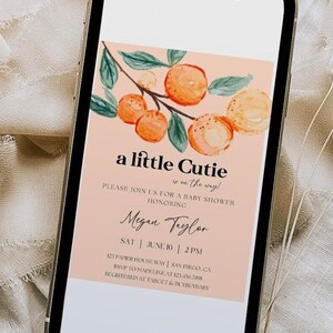 May include: A peach-colored baby shower invitation with a watercolor illustration of a branch with orange fruit and green leaves. The text reads "a little cutie is on the way!" and includes the name "Megan Taylor", the date "June 10", and the time "2PM".