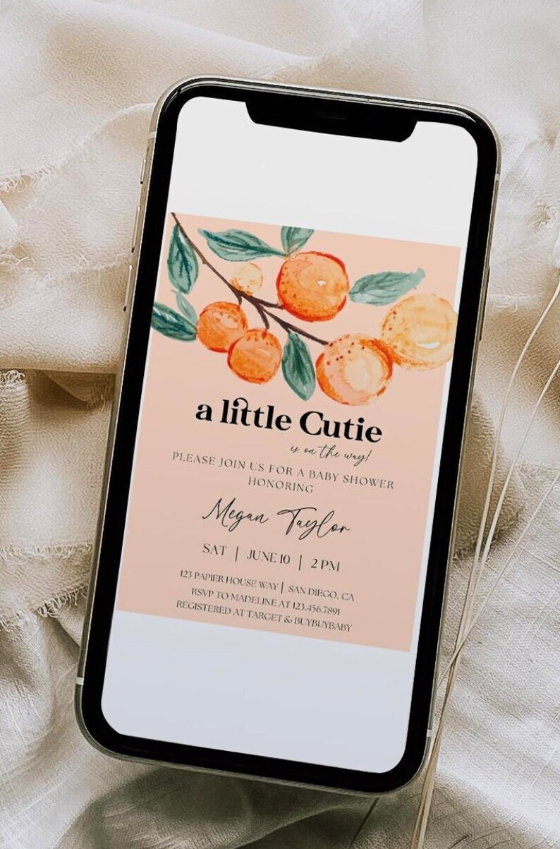May include: A peach-colored baby shower invitation with a watercolor illustration of a branch with orange fruit and green leaves. The text reads "a little cutie is on the way!" and includes the name "Megan Taylor", the date "June 10", and the time "2PM".