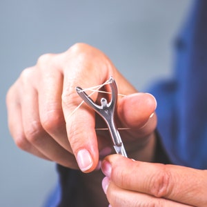 friendly floss the reusable floss holder replacing single use picks use with any floss thread your way control tension rotate wash reuse. image 5