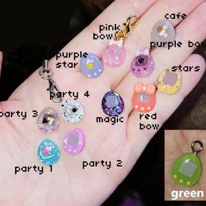 May include: A selection of colourful resin charms featuring bows, stars, and geometric shapes. The charms are in pink, purple, green, and blue, with glitter details. Some charms have the text "party 1", "party 2", "party 3", "party 4", "magic", "cafe", "stars", "red bow", "purple bow", and "pink bow".