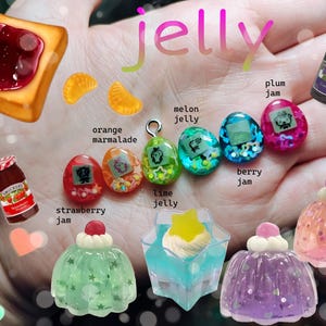May include: An assortment of colorful jelly-themed charms and miniature food items. Includes a slice of toast with jam, orange marmalade slices, jelly eggs, and miniature jelly desserts. The word "jelly" is written in pink script.