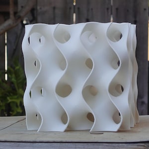 Large 8x8 gyroid sculpture with a modern, wave-like design and openings. Perfect as a fish or shrimp breeding cave or tank décor, this reef-safe, white habitat adds a coral-inspired aesthetic to aquariums while providing shelter for aquatic pets.