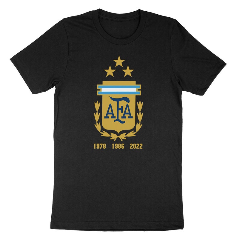 Op de afbeelding: Zwart T-shirt met een gouden wapenschild met de letters "AFA" en drie sterren. Het wapenschild is omringd door een lauwerkrans. De tekst "1978 1986 2022" is onder het wapenschild gedrukt.