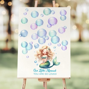 May include: A watercolour illustration of a mermaid sitting on a rock with bubbles surrounding her. The text "Our Little Mermaid You Are So Loved" is written below the mermaid.