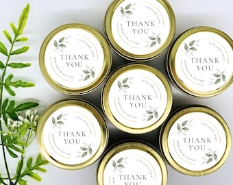 May include: Set of six gold metal candle tins with white labels. Each label features a green leafy design and the text "Thank You" with the date "11th June 20XX" and the names "Mariana & Oliver".
