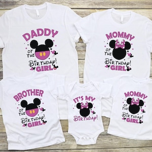 May include: A set of white t-shirts and a babygrow with matching designs for a birthday. Each garment features a Minnie Mouse head and text in pink, including "Daddy", "Mommy", "Brother", and "It's My Birthday!"