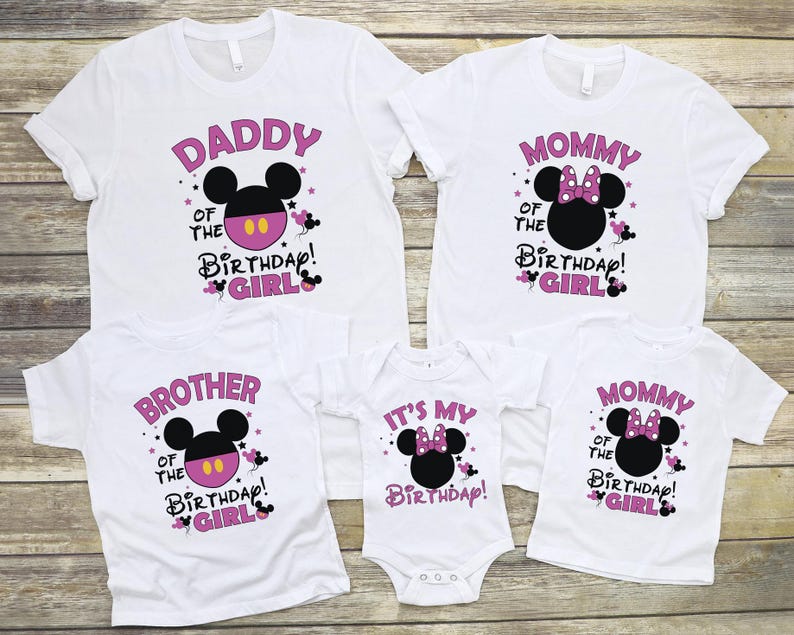 May include: A set of white t-shirts and a babygrow with matching designs for a birthday. Each garment features a Minnie Mouse head and text in pink, including "Daddy", "Mommy", "Brother", and "It's My Birthday!"