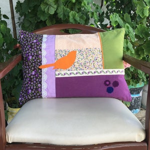 Patchwork cushion cover with lace, cross stitch embroidery, and appliqué