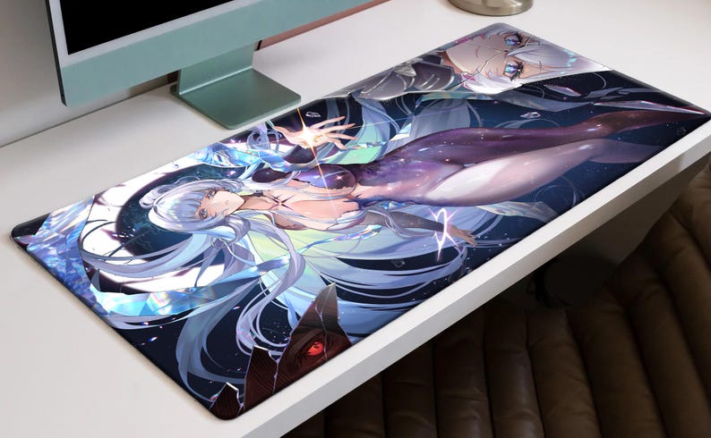 May include: A rectangular desk mat featuring a fantasy illustration of a woman with long, flowing silver hair and a purple and white outfit. The artwork has a celestial theme with blue and white accents.