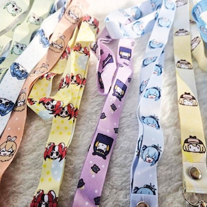 May include: A collection of colorful lanyards with various anime character designs. The lanyards are made of a soft, woven fabric and feature a variety of colors, including pink, blue, yellow, and green. Each lanyard has a different character design, including a girl with long hair, a girl with short hair, and a boy with a hat. The lanyards are perfect for adding a touch of personality to your keys, bags, or ID badges.