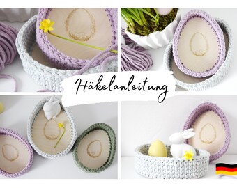 May include: Crochet Easter egg baskets in purple, grey, and green with wooden bases. The baskets are decorated with small yellow flowers and a white bunny. The text "Häkelanleitung" is visible in the image.
