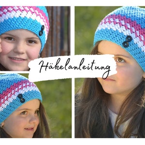 May include: A blue, pink and white crocheted beanie with black buttons. The beanie is shown on a child's head. The image also includes the text "Häkelanleitung" in German.
