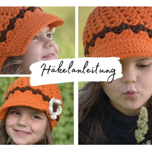 May include: A crocheted hat with a brim and a flower detail. The hat is orange and brown with a white flower. The hat is being worn by a child. The image includes the text "Häkelanleitung".