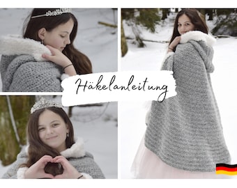 Op de afbeelding: Een meisje draagt een grijze, gehaakte cape met capuchon en een witte nep bontkraag. De cape wordt gedragen over een roze jurk. Het meisje draagt een tiara en glimlacht. De afbeelding heeft de tekst "Häkelanleitung" in het Duits.