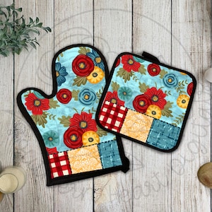 May include: A set of two blue and white floral pot holders with red and yellow accents. The pot holders have a patchwork design with a checkered pattern.