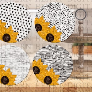 May include: Four round wooden coasters with a sunflower design. Each coaster features a different pattern: polka dots, black and white abstract, wood grain, and white stripes.